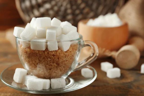 Coupe en verre avec grumeau et sucre brun sur fond en bois — Photo