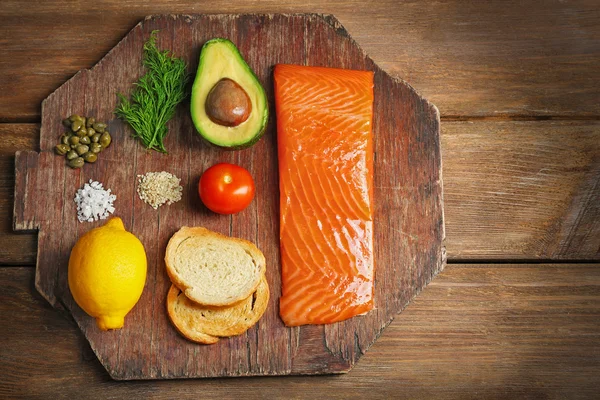 Ingredientes saborosos de tartare de salmão na tábua de corte, flat lay — Fotografia de Stock