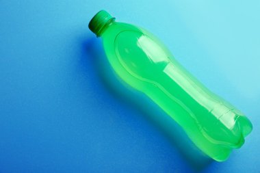 Mavi arka plan, üstten görünüm üzerinde alkolsüz içecek şişe