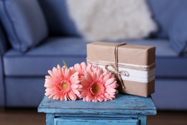 Mavi masada hediye kutusu ile pembe gerbera buketi yakın çekim