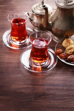 Siyah çay cam bardak ve ahşap masa üzerinde Doğu tatlılar