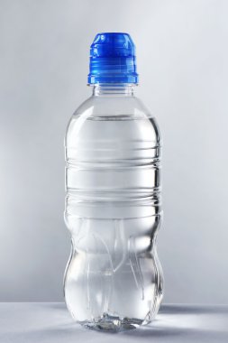 Şişelenmiş su gri arka plan üzerinde kapat
