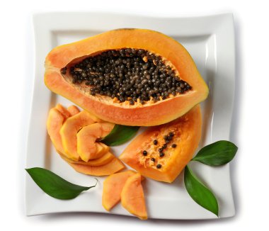 Beyaz tabakta dilimlerle yarıya papaya