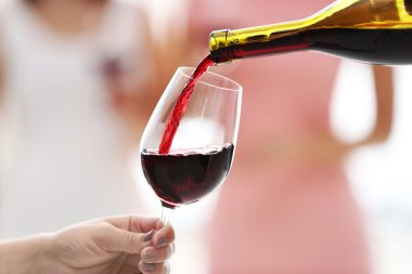 Kırmızı şarabı şişeden cama dök.