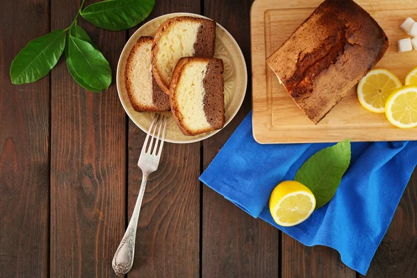 Delicious kue roti manis dengan lemon di atas meja kayu, top view — Stok Foto