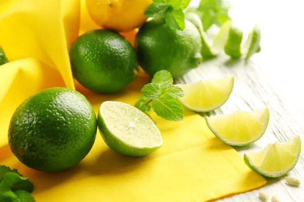 Fresh limes on yellow napkin — Stock Photo, Image