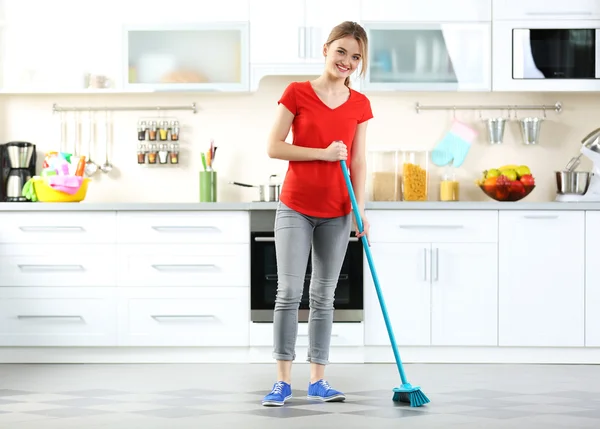 Wanita muda mencuci lantai di dapur — Stok Foto