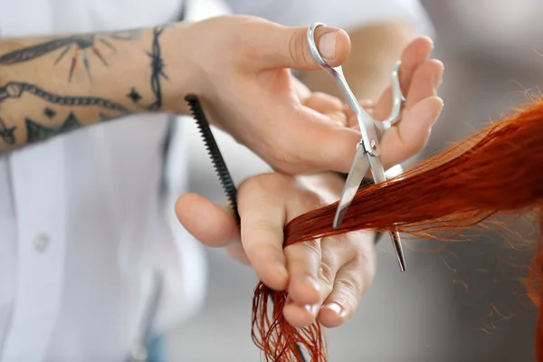 Hairdresser cutting red curls — Stock Photo, Image