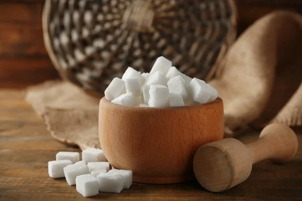 Holzschale mit Klumpen Zucker und Schlägel auf dem Tisch — Stockfoto