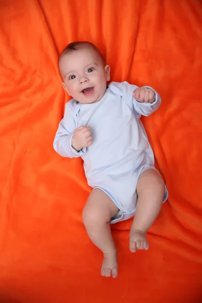 Bellissimo bambino su sfondo arancione — Foto Stock
