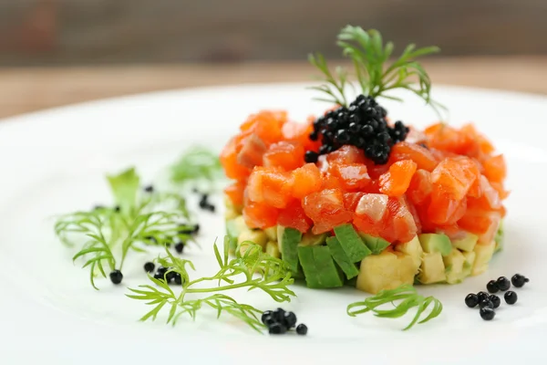 Deliziosa tartare di salmone con caviale nero su piastra bianca — Foto Stock