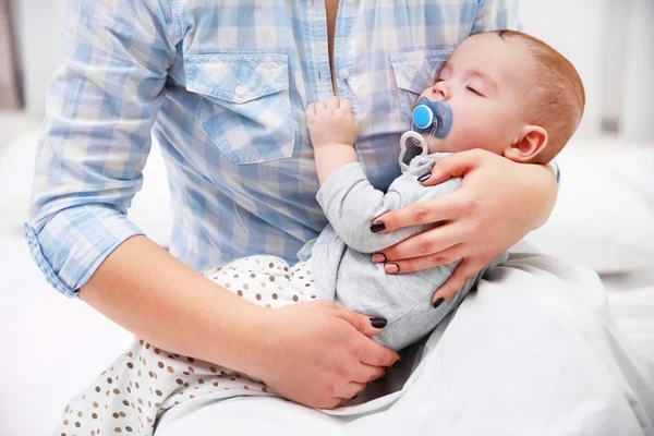 Baby med dummy sova i mammas händer — Stockfoto