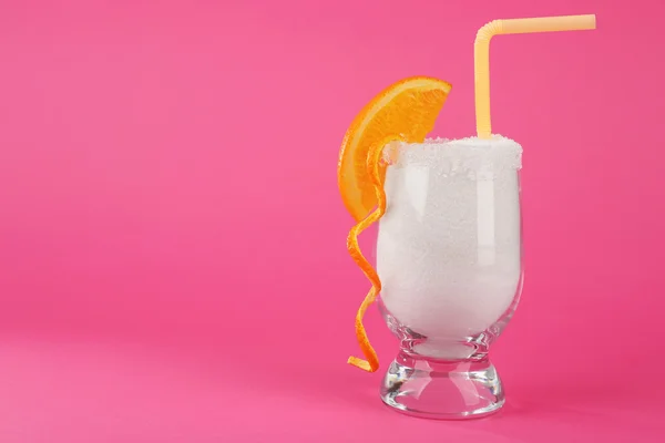 Glass with granulated sugar, cocktail straw and orange slice on pink background — Stock Photo, Image