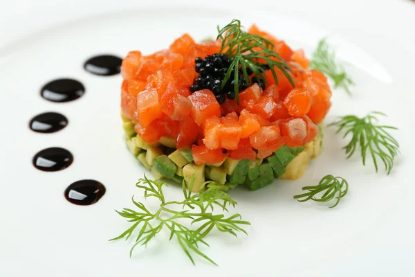 Delicioso tártaro de salmón con caviar negro en plato blanco —  Fotos de Stock