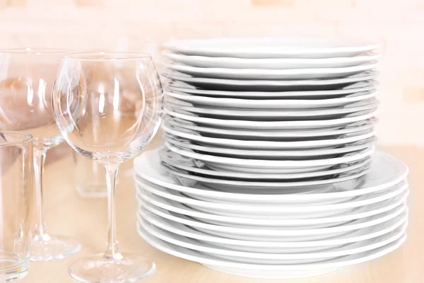 Čisté nádobí a sklenice na dřevěný stůl. — Stock fotografie