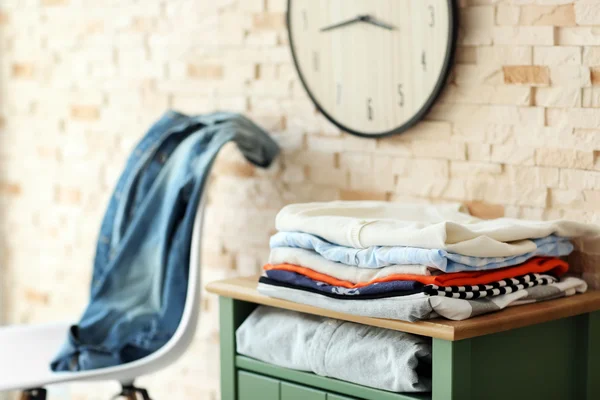 Roupas masculinas deitadas na mesa de cabeceira na frente do fundo da parede de tijolo — Fotografia de Stock