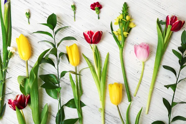 Stelletje verse bloemen op de witte tafel. Bovenaanzicht. — Stockfoto