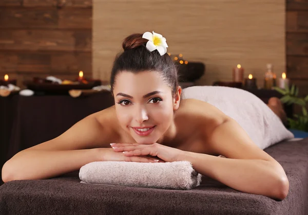 Bella ragazza con asciugamano sdraiato sul tavolo da massaggio nel salone spa — Foto Stock