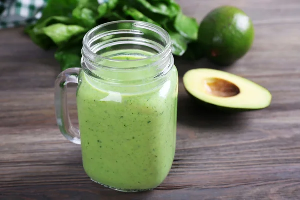 Jar of avocado cocktail with spinach on wooden background — Stock Photo, Image