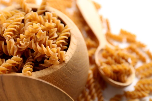 Trockene italienische Pasta in einer hölzernen Schüssel, Nahaufnahme — Stockfoto