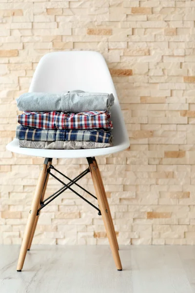 Mannelijke kleren op de stoel voor bakstenen muur achtergrond — Stockfoto