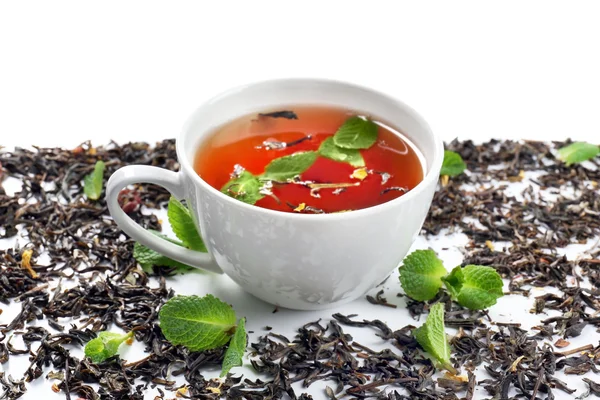 Tasse de thé avec des feuilles sèches sur fond blanc — Photo