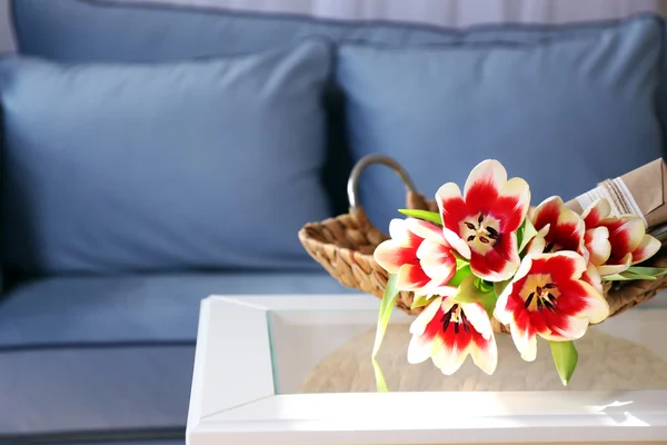 Strauß buntgemischter Tulpen mit Geschenkschachtel im Korb auf dem Tisch — Stockfoto