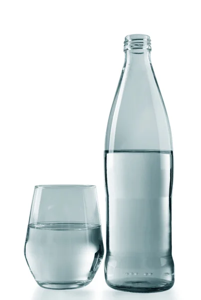 Bottled water with a glass on the grey background, close up — Stock Photo, Image