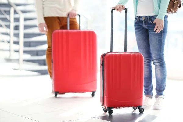 Para czeka z dużym walizkami czerwonego, z bliska — Zdjęcie stockowe