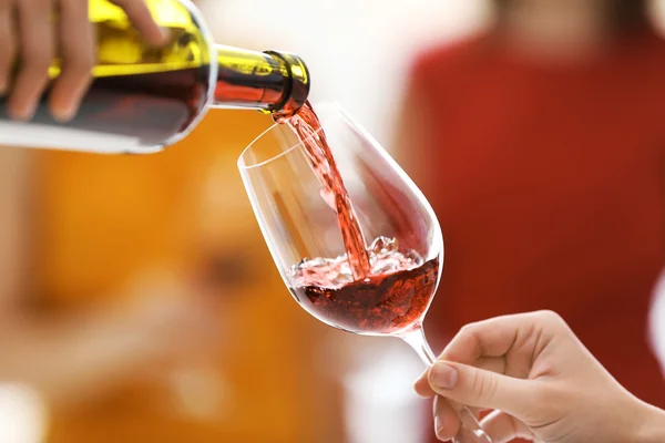 Versare il vino rosso dalla bottiglia nel bicchiere, da vicino — Foto Stock