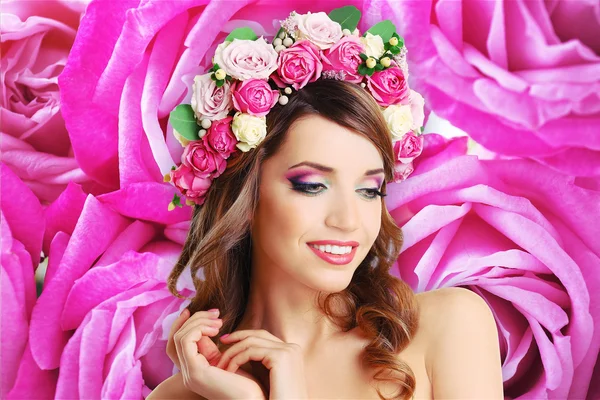 Krásná žena na pozadí s květinami — Stock fotografie