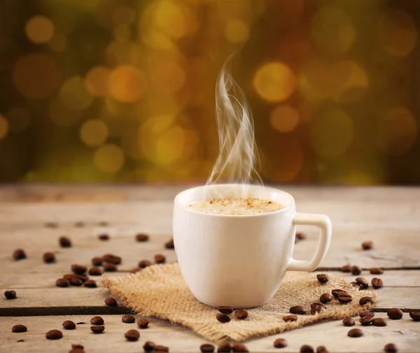 Tasse Kaffee auf Tisch auf braunem Hintergrund — Stockfoto
