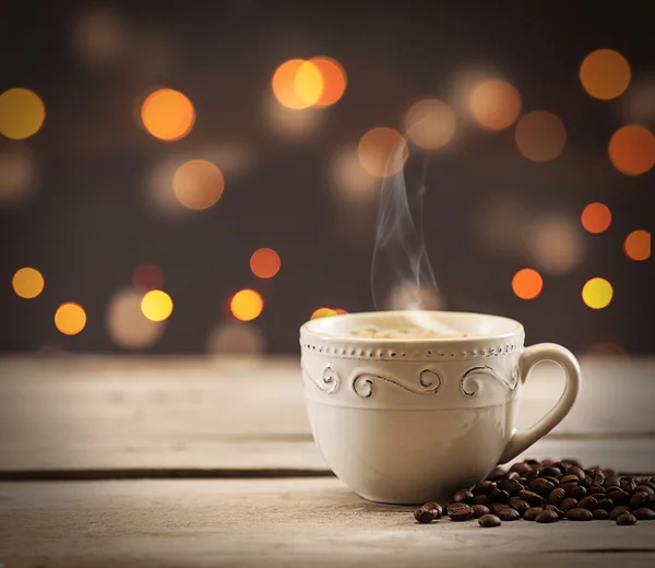 Taza de café con granos sobre fondo marrón —  Fotos de Stock