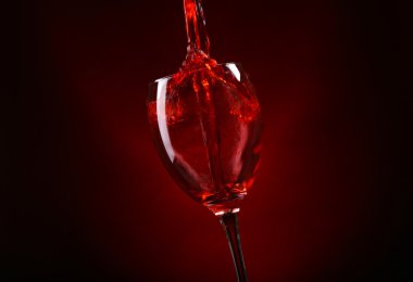Cam koyu kırmızı zemin üzerine dökme şarap