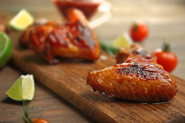 Izgara tavuk kanadı Bahçe-in ve kesme tahtası üzerinde domates ile