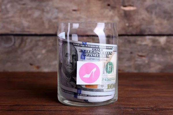 Rollo de billetes de dólar en un frasco de vidrio — Foto de Stock