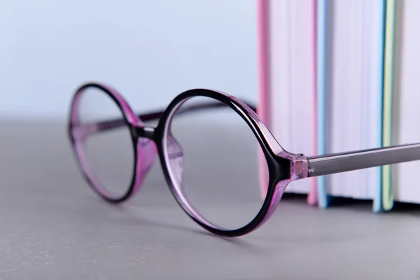 Books and eyeglasses on grey table — Stock Photo, Image