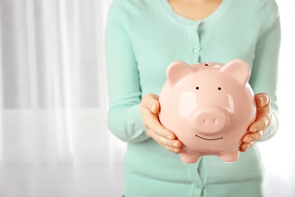 Vrouw met piggy bank in handen — Stockfoto