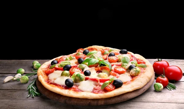 Deliziosa pizza con formaggio e verdure su sfondo nero — Foto Stock