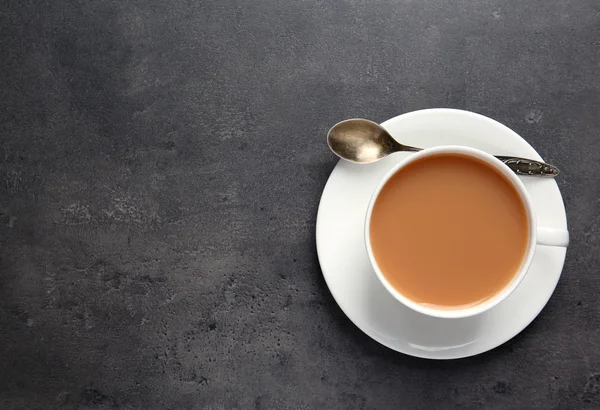 Porcellana tazza di tè con latte su sfondo grigio — Foto Stock