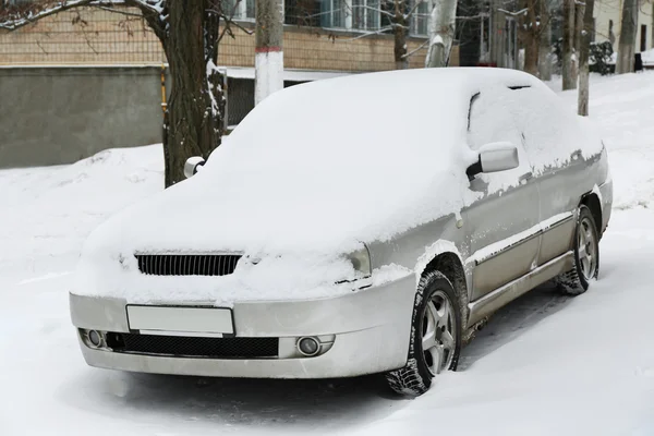 Pokryte śniegiem samochód obok budynku — Zdjęcie stockowe