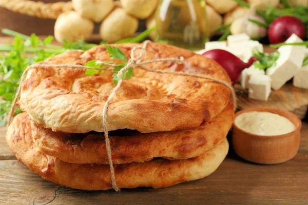 Fresh fried bread with other products on wooden table closeup — Stock Photo, Image