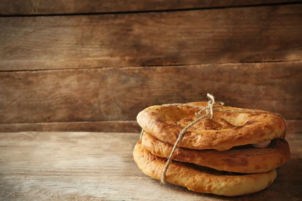 Čerstvý smažený chléb na dřevěné pozadí — Stock fotografie