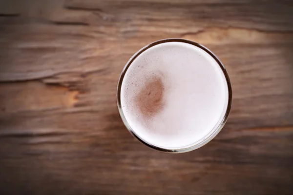 Glas helles Bier auf hölzernem Hintergrund — Stockfoto