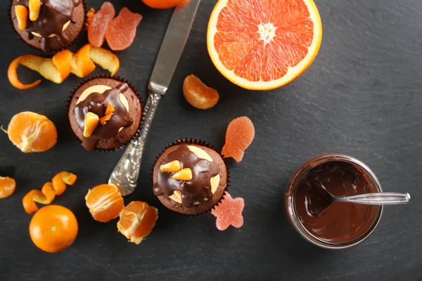 Välsmakande cupcake med frukt, choklad och kniv på skiffer plattan — Stockfoto