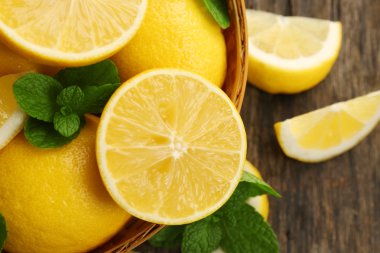 Ahşap masa portre üzerinde kase yeşil yaprakları ile taze limon