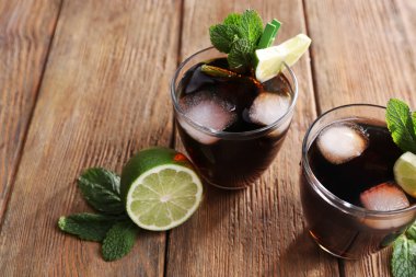 Buz, nane ve limon ahşap masa arka plan üzerinde cola iki bardak