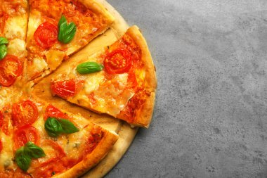 Margherita pizza gri arka plan üzerine dilimlenmiş