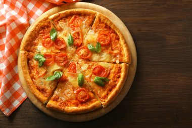 Margherita pizza ahşap arka plan üzerine dilimlenmiş