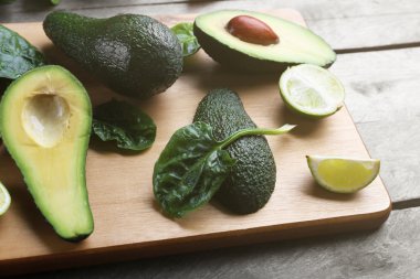 Kireç ve ahşap kesme tahtası üzerinde ıspanak ile dilimlenmiş avokado